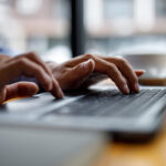 Close up of hands typing on computer keyboard